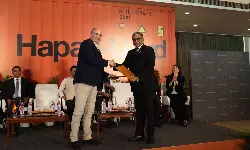 (L-R) Rolf Habben Jansen, Chief Executive Officer of Hapag–Lloyd, exchanging MoU for vessel reflagging with Shyam Jagannathan, Director General of Shipping, in the presence of Sarbananda Sonowal, Union Minister for the Ministry of Ports, Shipping and Waterways (MoPSW), at the announcement held in Mumbai on March 19, 2026. (L-R) Rolf Habben Jansen, Chief Executive Officer of Hapag–Lloyd, exchanging MoU for vessel reflagging with Shyam Jagannathan, Director General of Shipping, in the presence of Sarbananda Sonowal, Union Minister for the Ministry of Ports, Shipping and Waterways (MoPSW), at the announcement held in Mumbai on March 19, 2026.